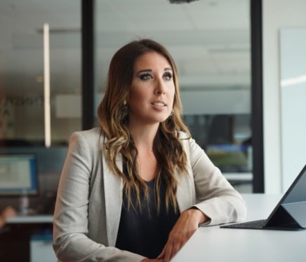 Lifestyle portrait of a young female executive at her workstation as she looks thoughtfully off-camera